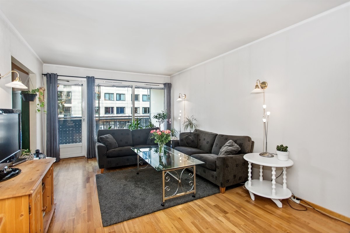 Stuen har parkett på gulv og lysmalte overflater Galleribilde