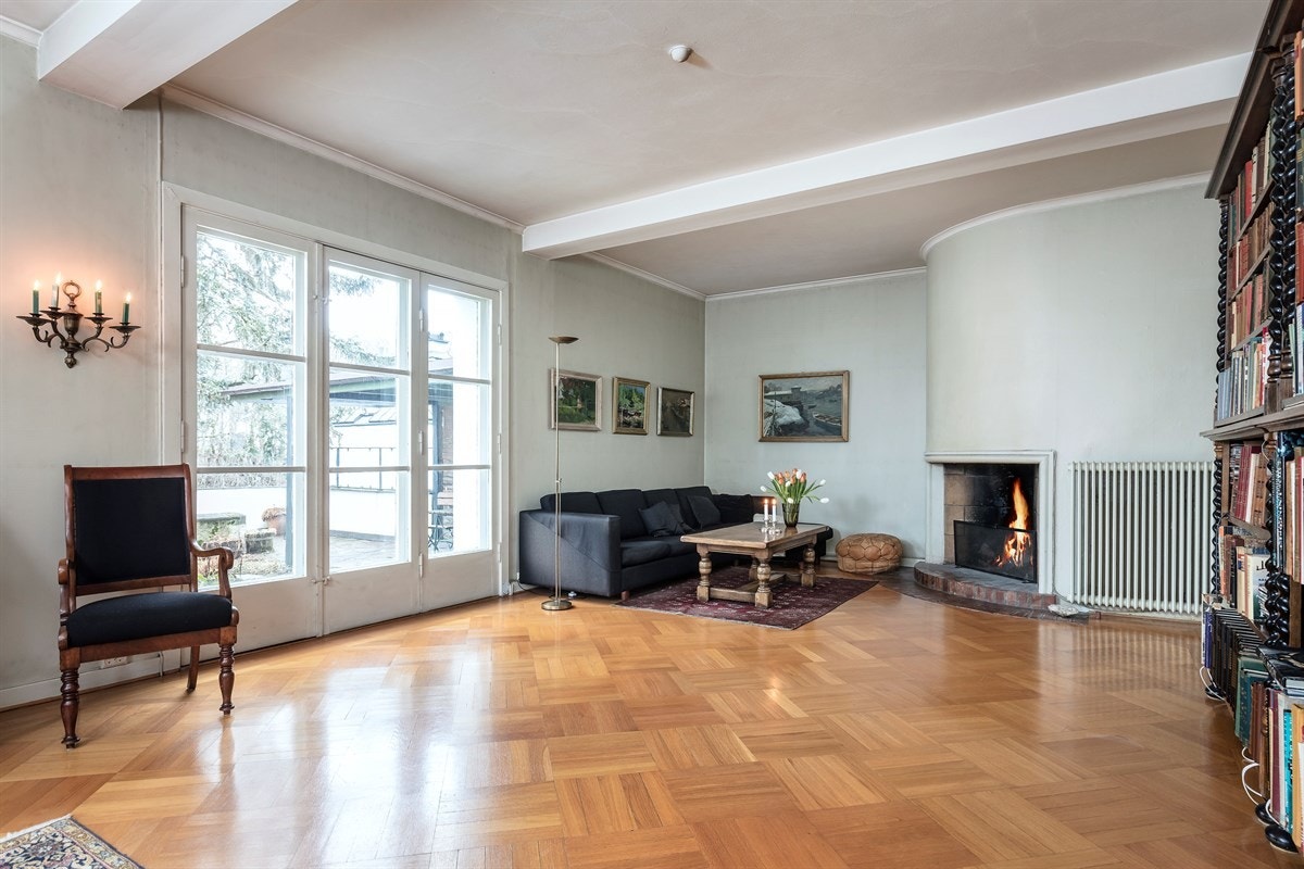 Stor stue med åpen peis og utgang til terrasse/hage Galleribilde