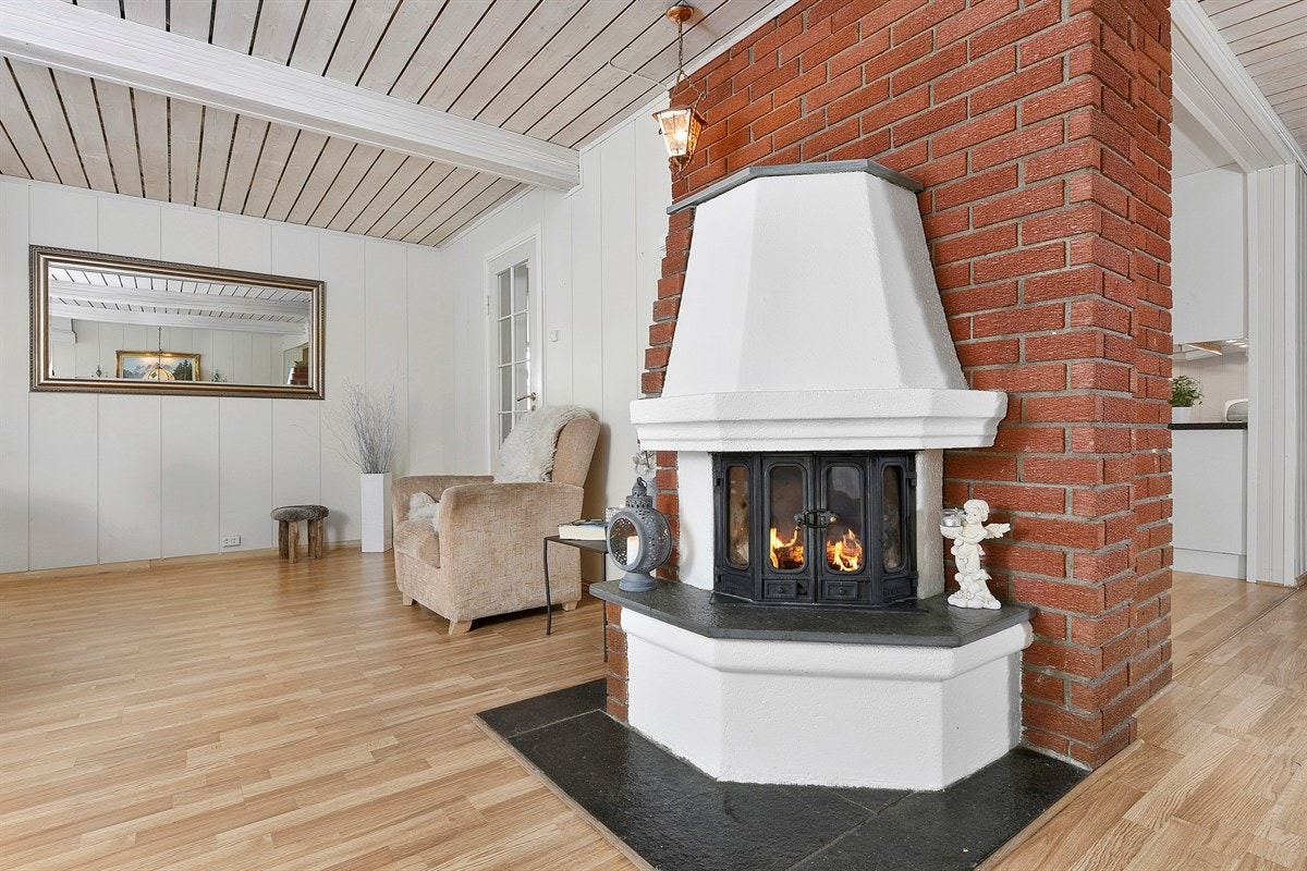 Stuen har både peis med innsats og varmepumpe som gir god komfort. Galleribilde