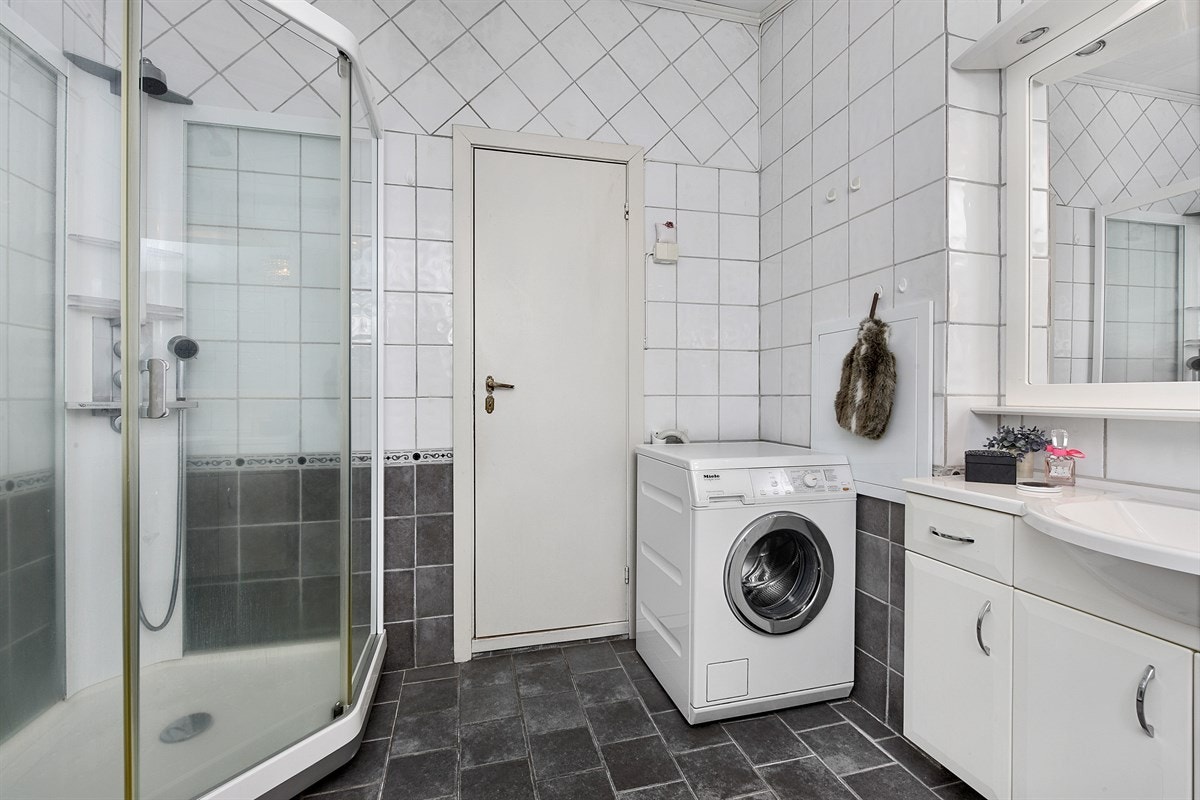 Badet i første etasje ble modernisert for ca. 5 år siden. Rommet toalett, dusjkabinett og opplegg for vaskemaskin og tørketrommel Galleribilde