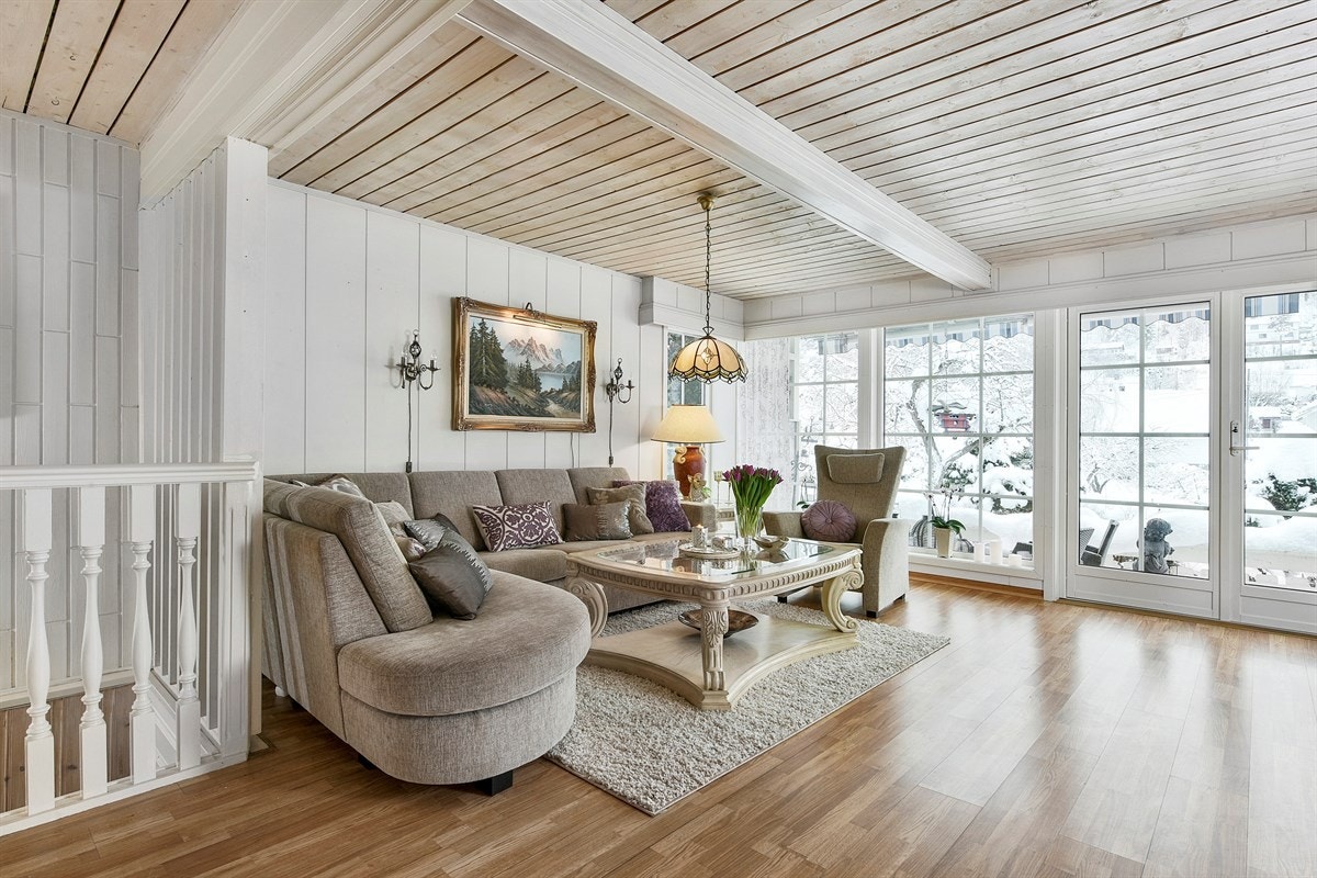 Stuen ligger åpent mot hall/kjøkken og har flotte sprossevinduer i flere himmelretninger som sørger for luftig atmosfære og fine lysforhold. Galleribilde
