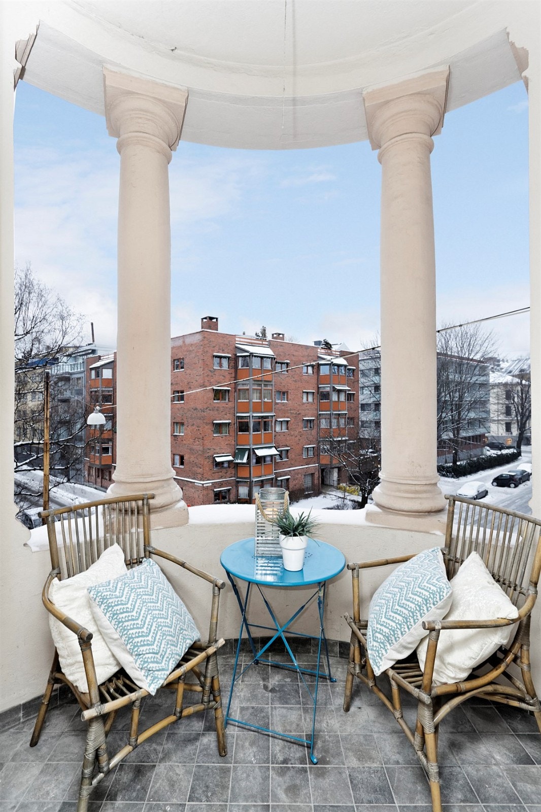 Koselig overbygd balkong med søyler og fliser på gulv. Galleribilde