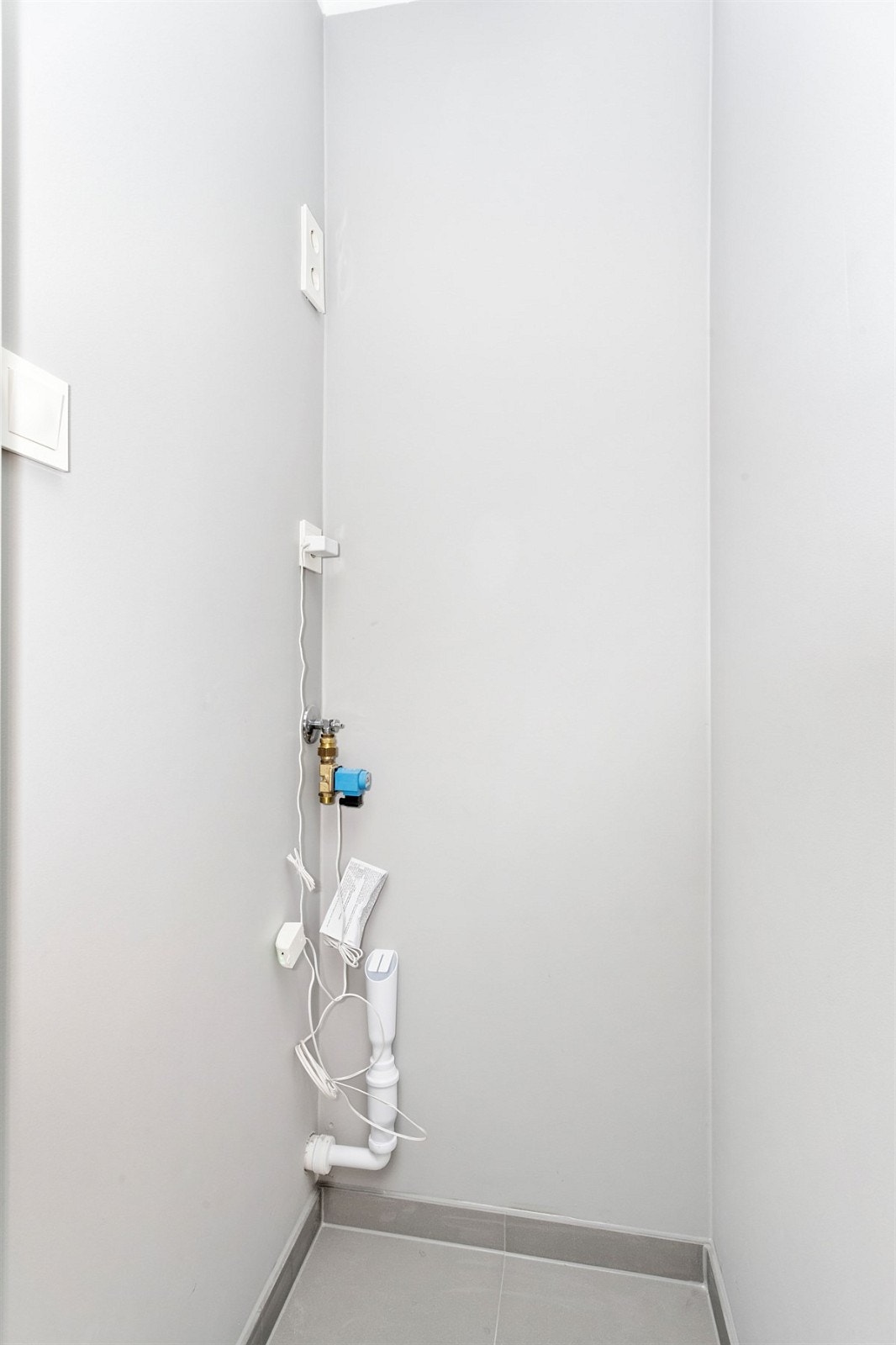 Vaskerommet har opplegg for vaskemaskin og tørketrommel. Fliser på gulv. Galleribilde