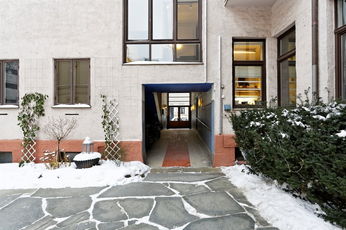 Hyggelig steinbelagt bakgård med prydbusker og planter. Galleribilde