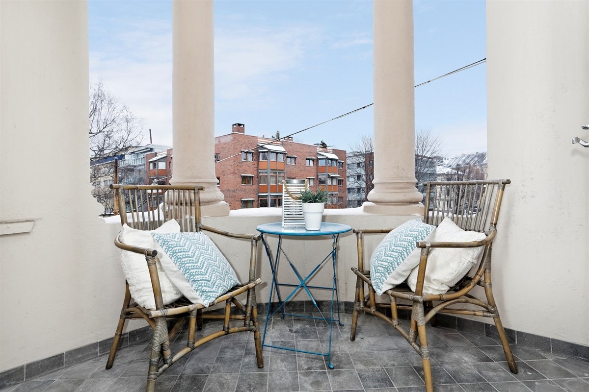 Koselig overbygd balkong med søyler og fliser på gulv. Galleribilde