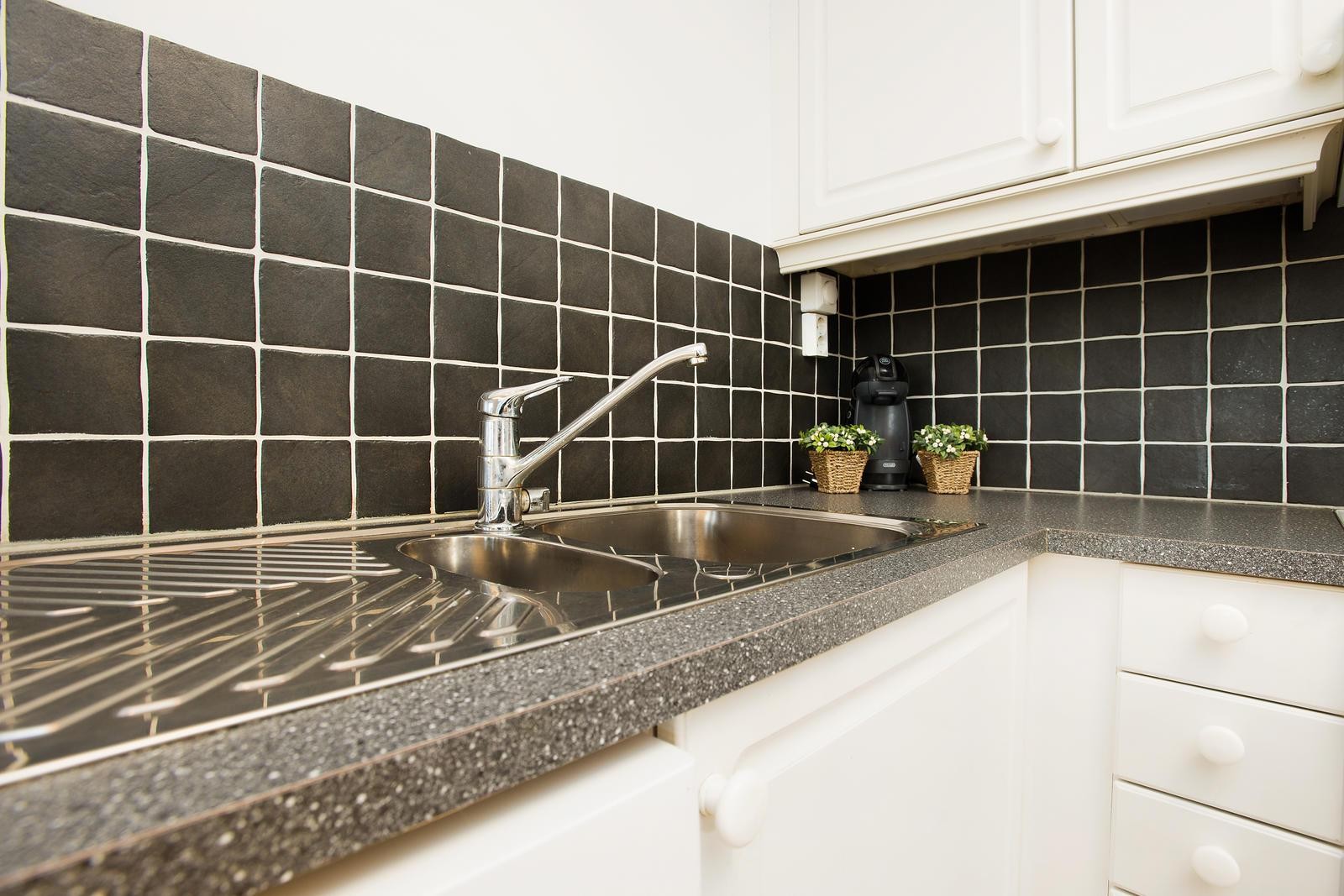 Fliser over benk og belysning under overskap. Galleribilde