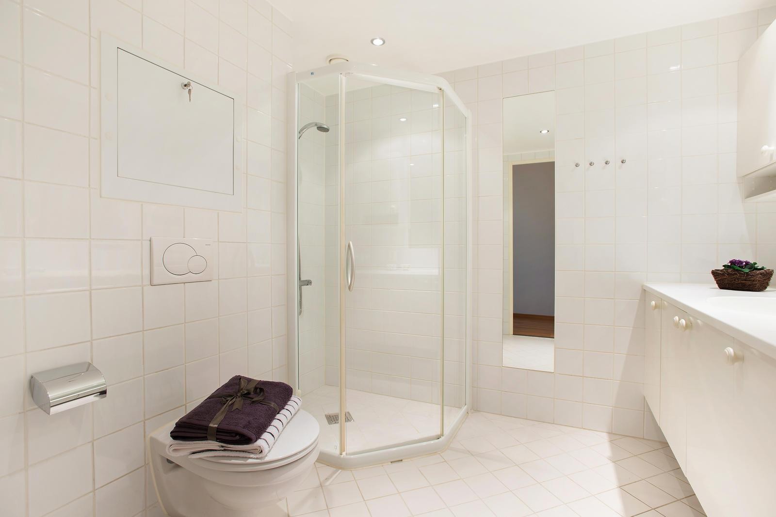 Pent, flislagt bad med opplegg for vaskemaskin. Galleribilde