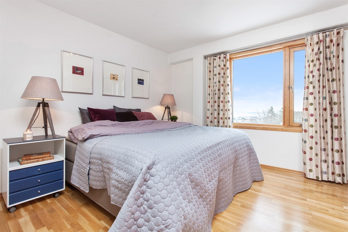 Friskt og luftig soverom med stor vindusflate og utsikt mot skogen, byen og Trondheimsfjorden. Rommet er på hele 13 kvm og har luftventil for en behagelig luft til nattesøvnen. Galleribilde