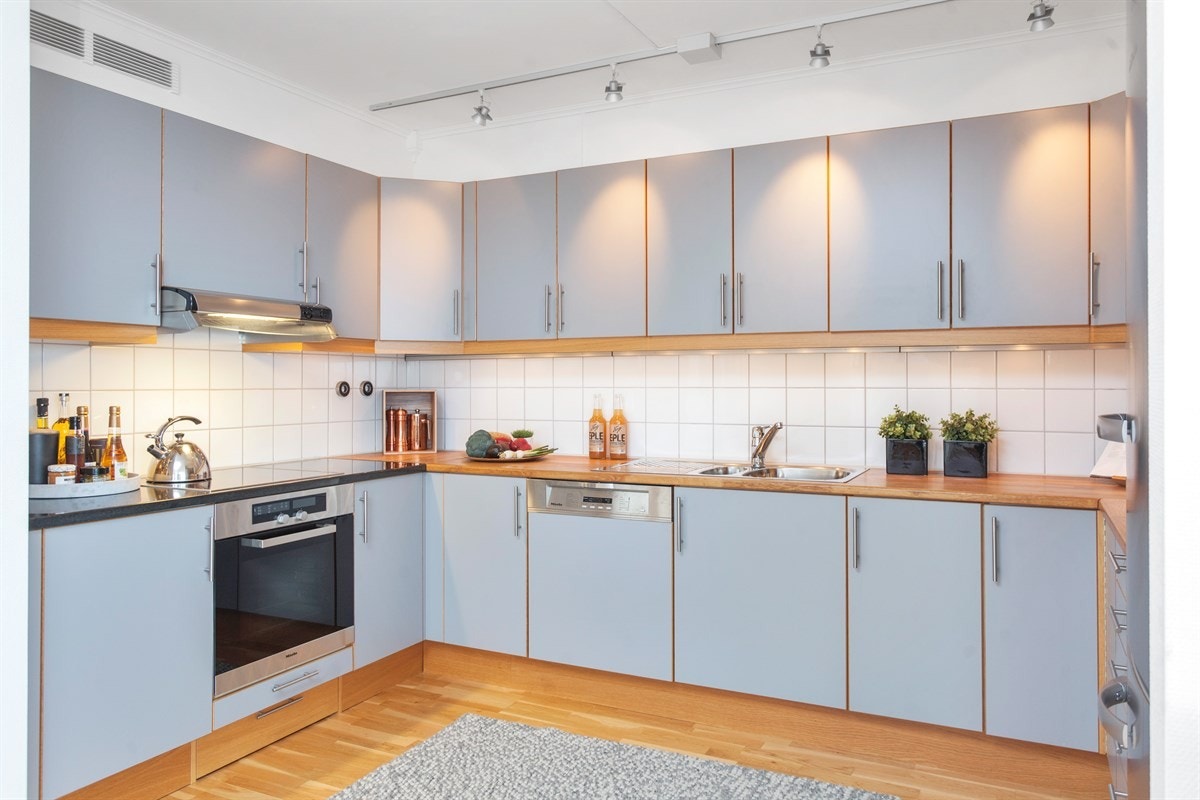 Benkeplaten består av en del med heltre hvor vi finner en nedfelt oppvaskkum med avrenn, og en del med benkeplate i lekker, sort stein som har koketopp. Galleribilde