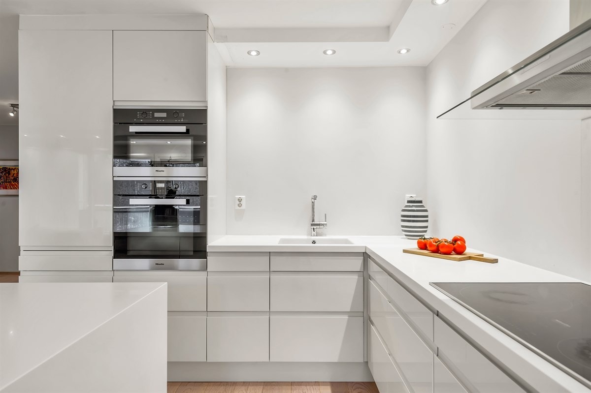 HTH kjøkken fra 2014. Elegant håndtaksløst innredning med hvite, høyglans fronter. Galleribilde