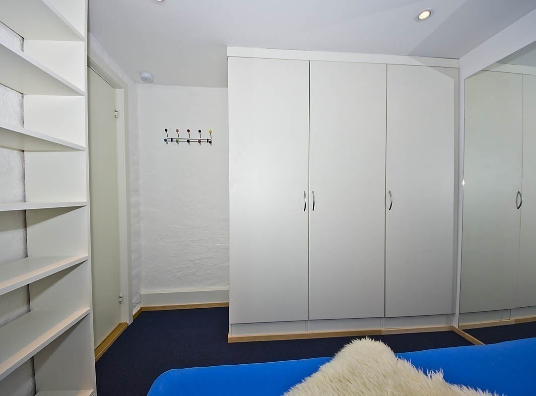 Rom nummer 3 er litt mindre, og har en 120 cm dobbeltseng. Derimot har dette rommet formidabel garderobeplass, med tre høye skap og en integrert bokhylle. I taket er dimbare innfelte downlights, og på gulvet en kombinasjon av teppe og parkett. Galleribilde