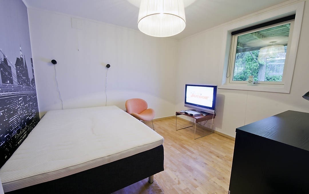 Rom nummer 2 har ny og elegant kontorpult med skuffer og skap, et stort romslig kleesskap og en queen size dobbeltseng. Ene veggen er en fototapet med storby-motiv og i taket henger en veldig spesiell designlampe. Her er også stort vindu ut til hage, med Galleribilde