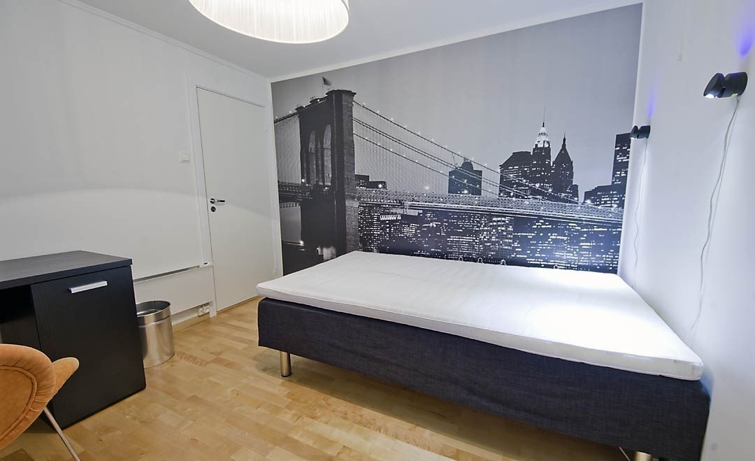 Rom nummer 2 har ny og elegant kontorpult med skuffer og skap, et stort romslig kleeskap og en queen size dobbeltseng. Ene veggen er en fototapet med storby-motiv og i taket henger en veldig spesiell designlampe. Her er også stort vindu ut til hage, med r Galleribilde