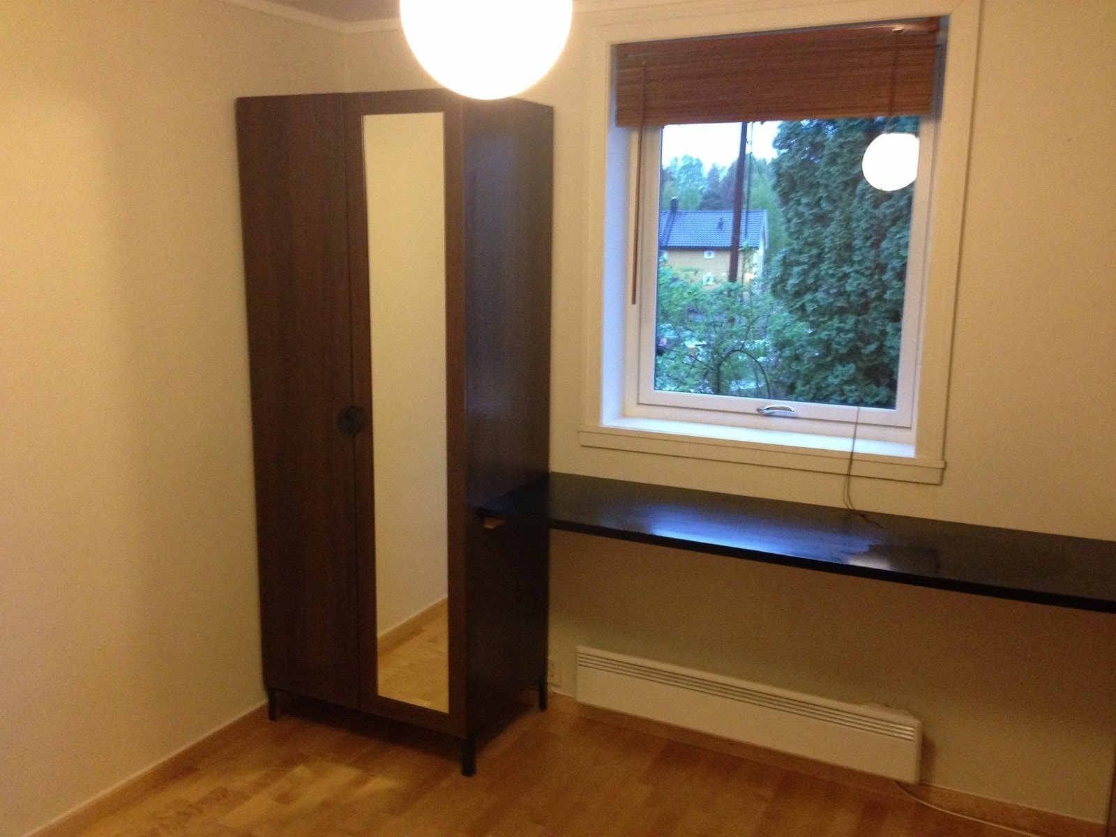 Rom nummer 1 har en lang skrivepult langs veggen, et stort klesskap, en stor moderne kleskommode med skap. Her er en stor 180 cm dobbeltseng. Det er full høyde vindu ut med koselig utsikt til hage og persienne i tre. Moderne funkis kulelampe i taket, og n Galleribilde