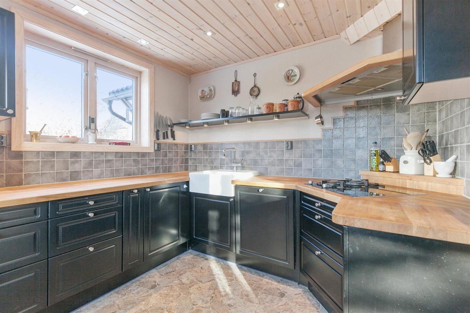 Innredet med svarte, malte, profilerte skapdører.
Det er rikelig med benke- og lagringsplass. Galleribilde