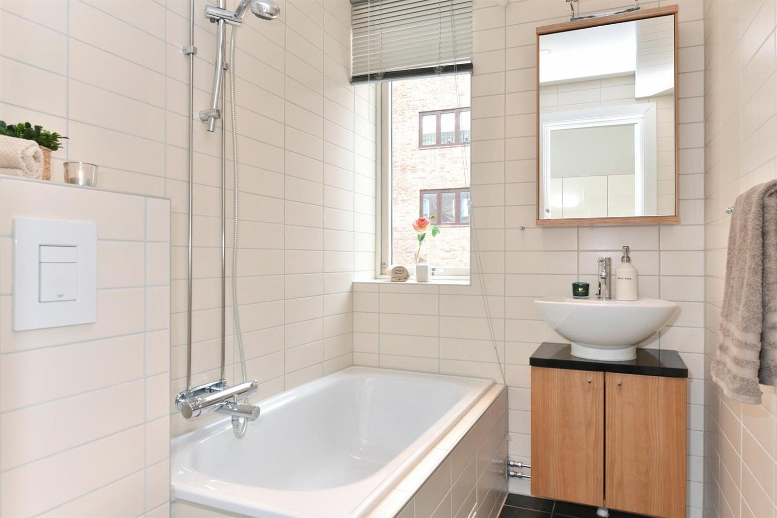 Bad med vegghengt wc, badekar og baderomsinnredning med servant. Felles varmtvann. Galleribilde