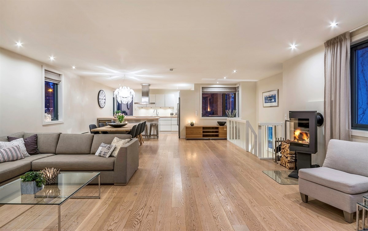 Stuen har enstavs eikeparkett på gulv, downlights i himling, vegger malt i beige/hvitt Galleribilde