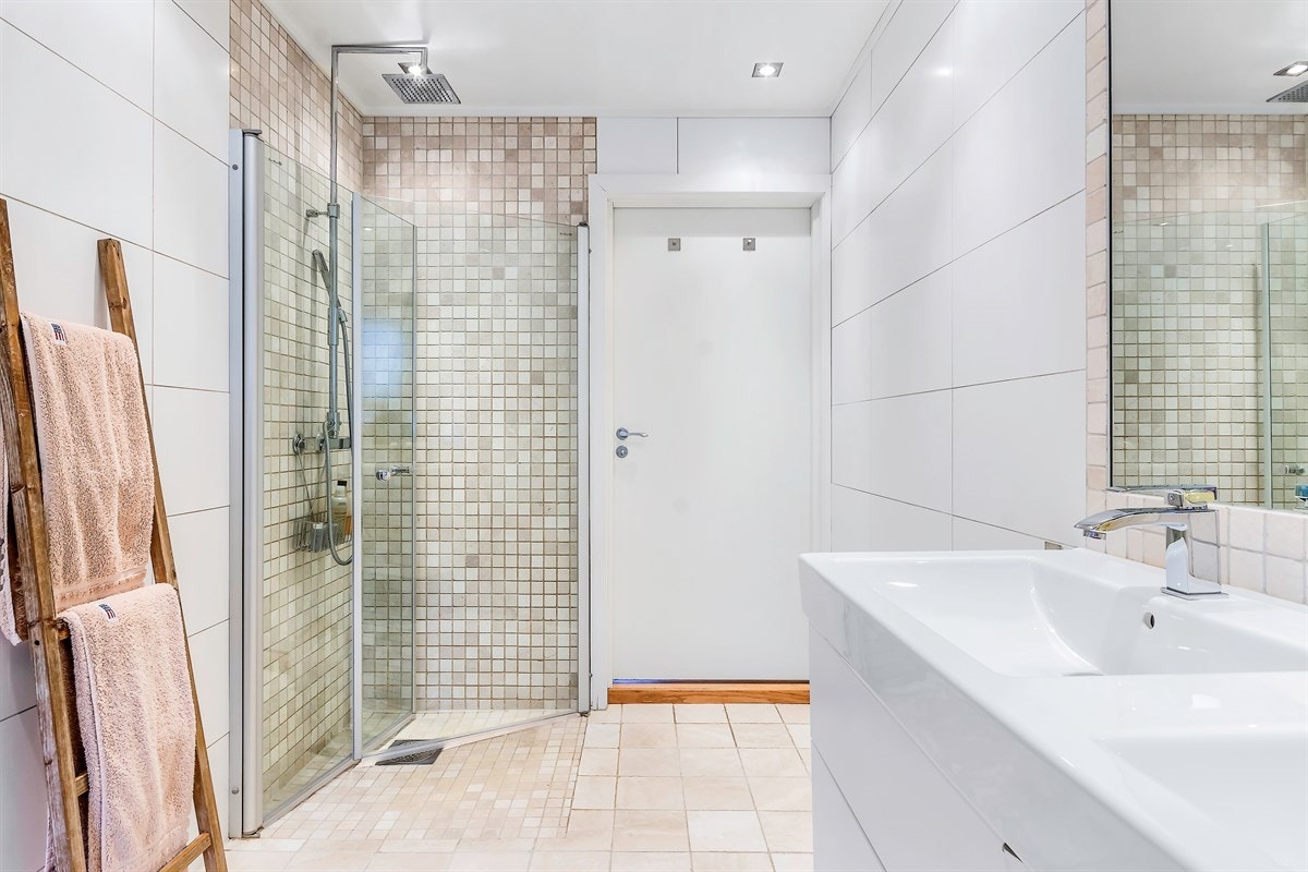 Boligen har et delikat baderom i første etasje, med adkomst fra både gang og walk-in-closet tilknyttet hovedsoverommet Galleribilde