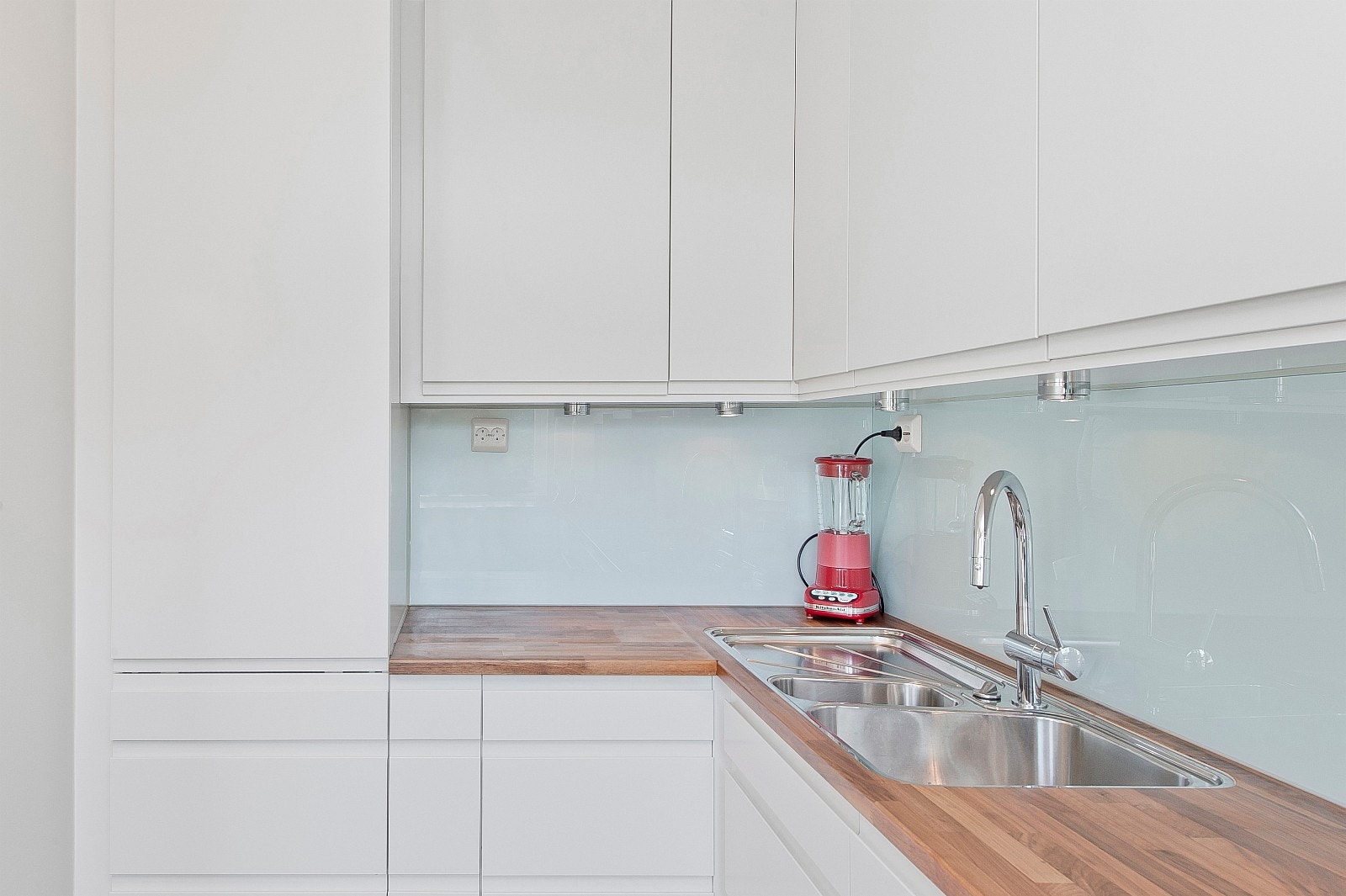 Kjøkkenet har et moderne uttrykk med håndtakløse fronter og integrerte hvitevarer. Galleribilde