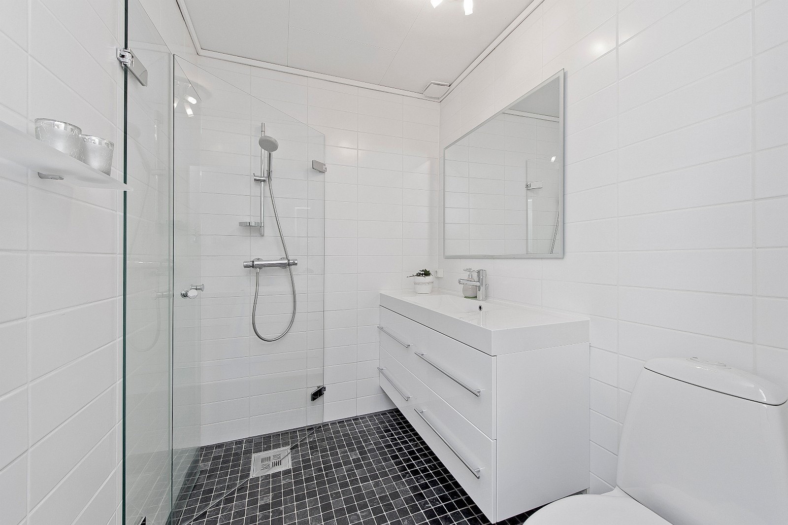 Badet ble flislagt i 2007. Dusj med innfellbare glassdører. Moderne baderomsinnredning i høyglans hvit. Galleribilde