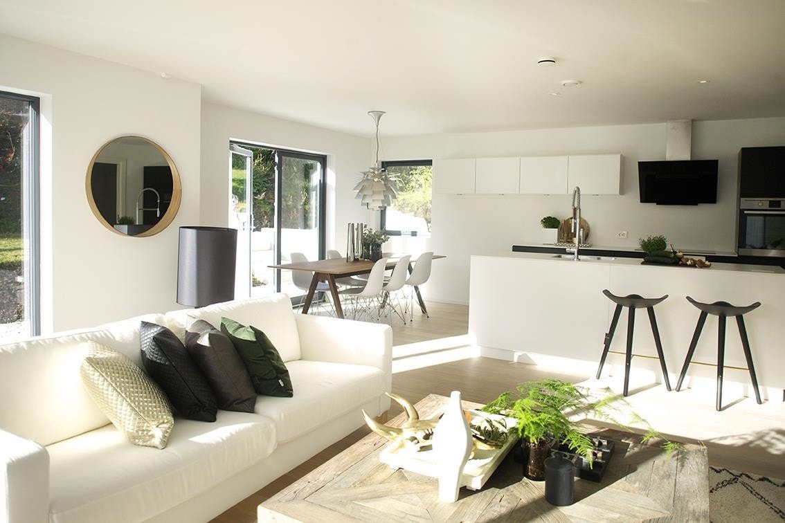 Stuen nede ligger åpent mot kjøkkenet og er full av lys fra de store vinduene. Galleribilde