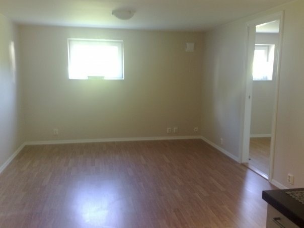 Stue med varme i gulv, står en hjørnesofa i grå der. Galleribilde