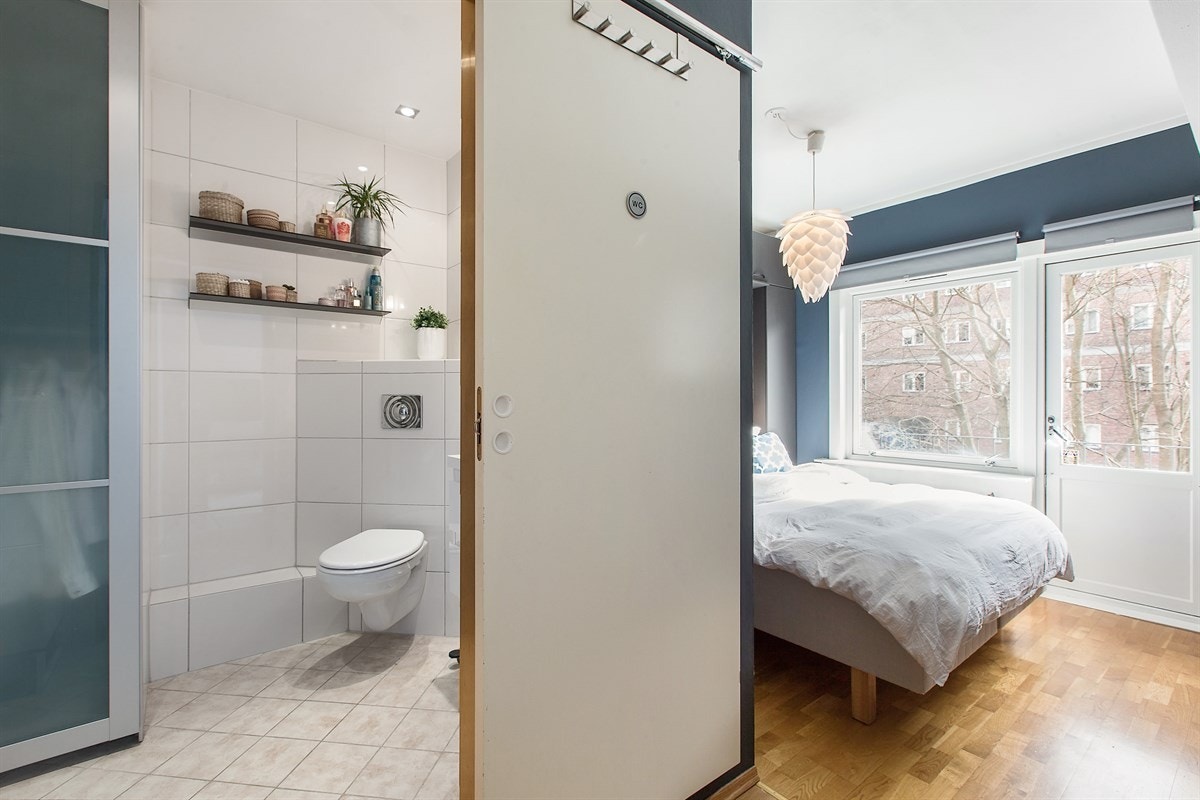 En plassbesparende, smart skyvedørsgarderobe viser veien videre inn til badet. Galleribilde