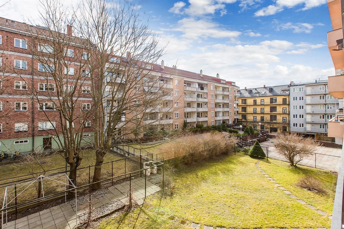 Fra balkongen får du fint utsyn gårdsrommets plener og dekorative beplantning. Galleribilde