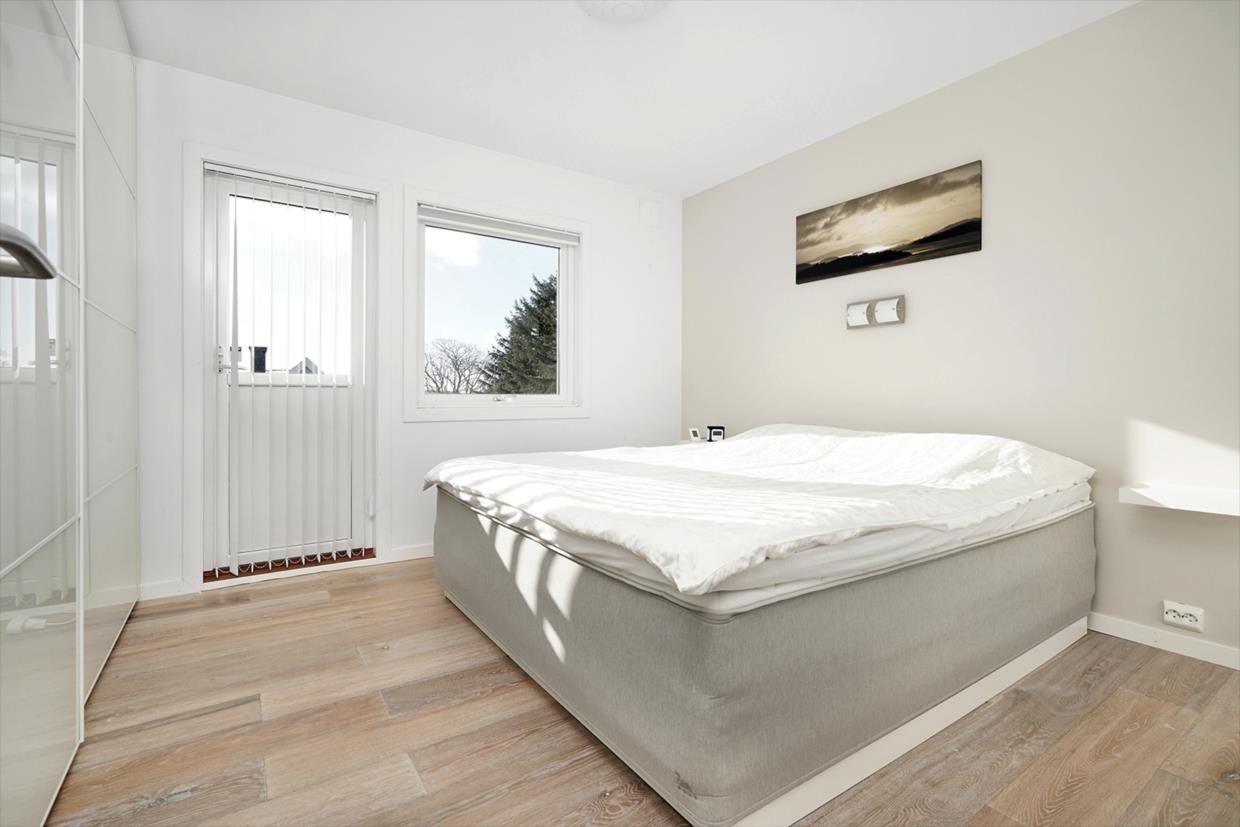 Hovedsoverom med utgang til lufteveranda. Det er skyvedørsgarderobe her. Galleribilde