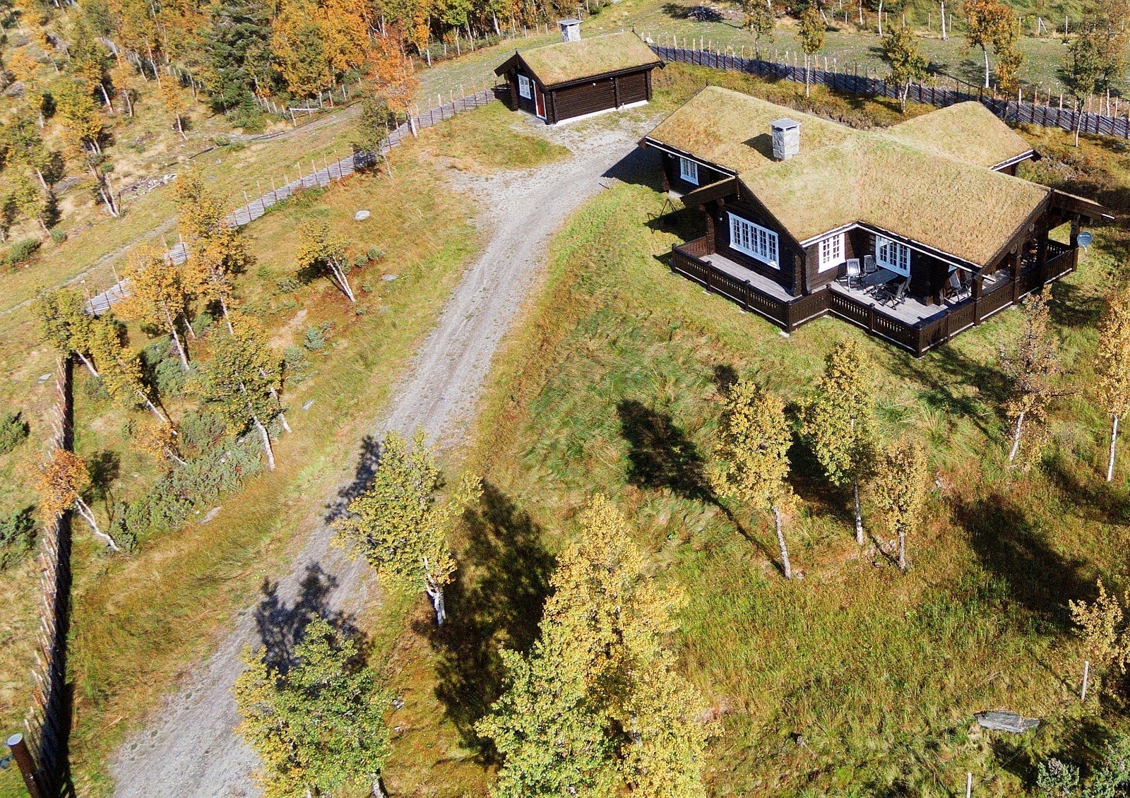 Hytten ligger i skrånet terreng og har stor tomt med skigard. Galleribilde