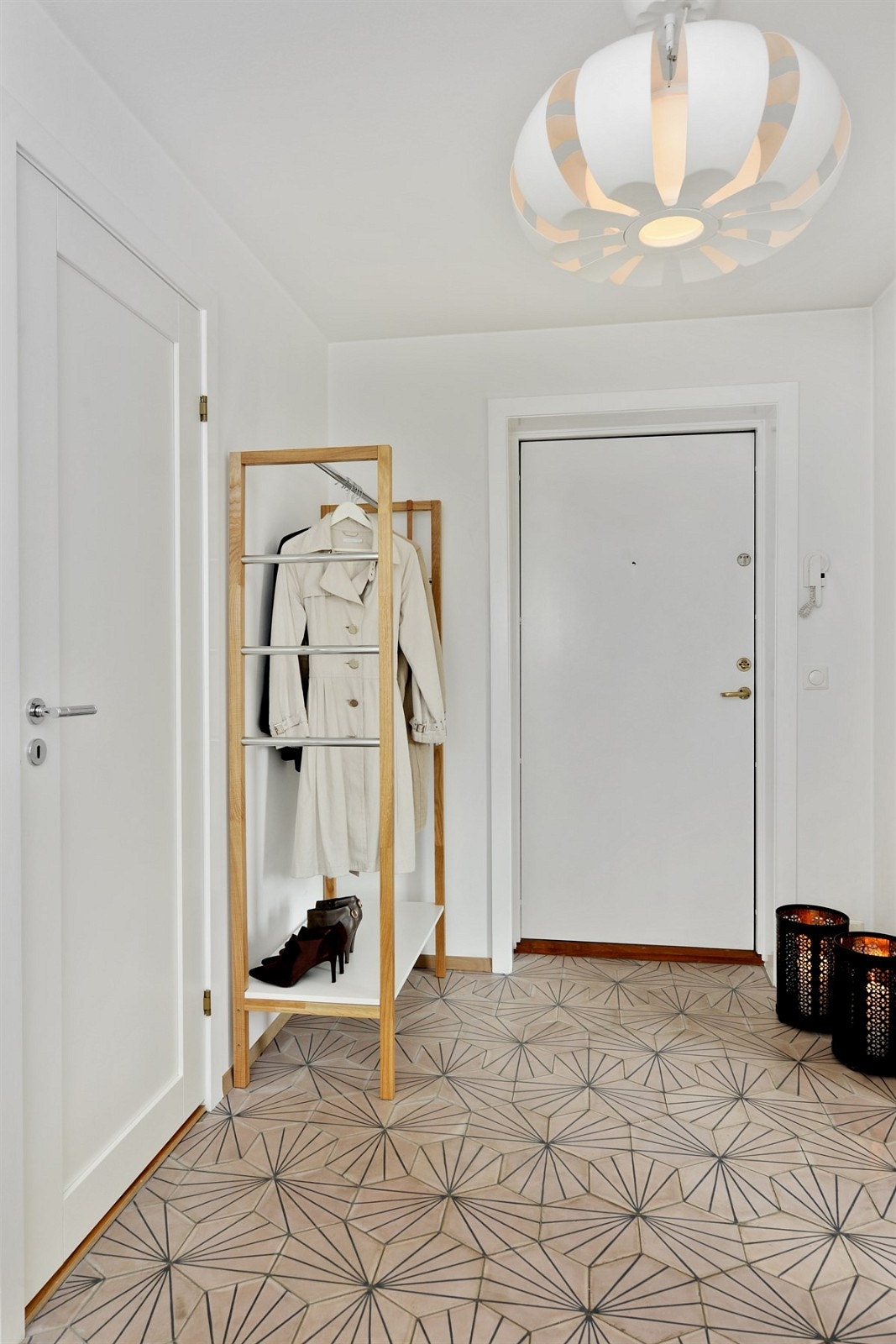 Stor gang med fliser på gulv og oppheng for ytterplagg Galleribilde