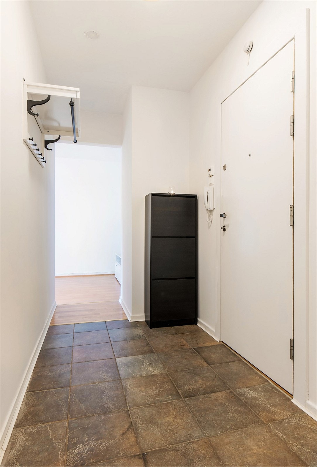 Entreen er pent innredet med steinmønstrede fliser på gulv, samt hvitmalte vegger og listverk. Her er det god plass for både åpen garderobeløsning og skoskap. Galleribilde