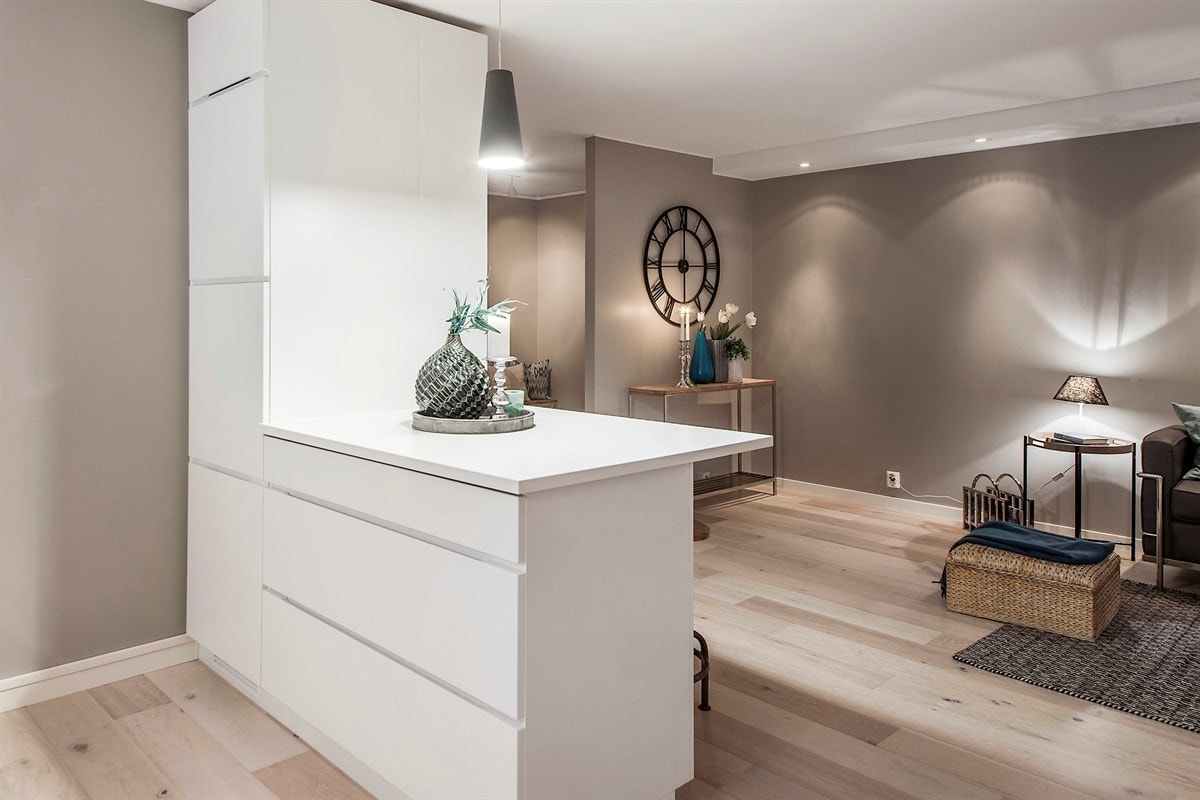 Kjøkkenet fra KVIK er nytt og fremstår som stilrent. Alle hvitevarene er fra Bosch, og integrert i en moderne innredning med glatte fronter. Bardisk mot stuen med sitteplasser. Galleribilde