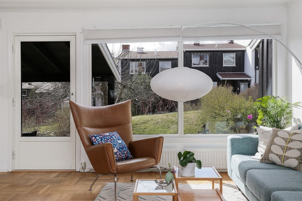 Store vindusflater som slipper sommeren inn i stuen. Galleribilde