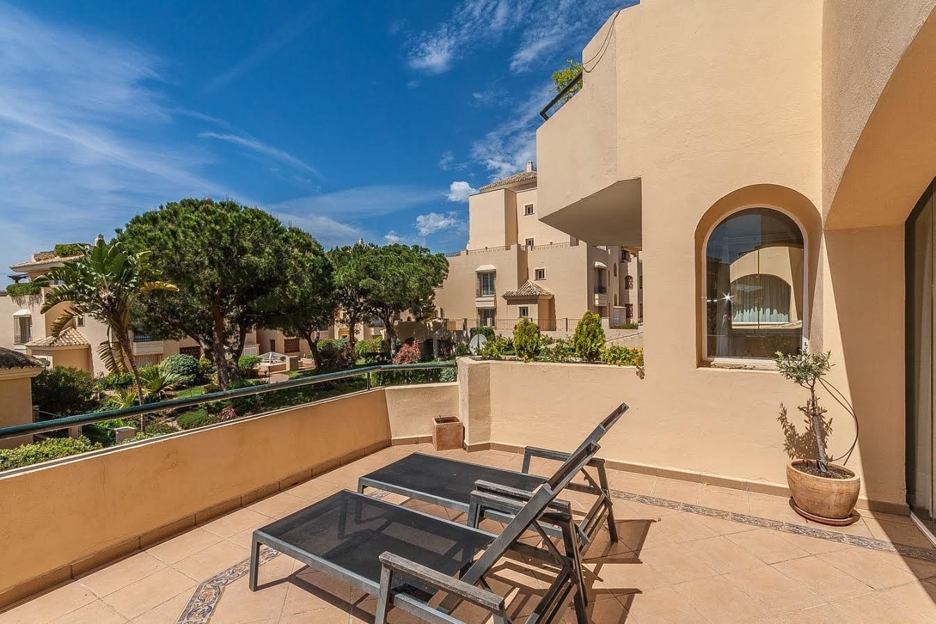 Terasse ute med blikk mot parkmessig hage Galleribilde