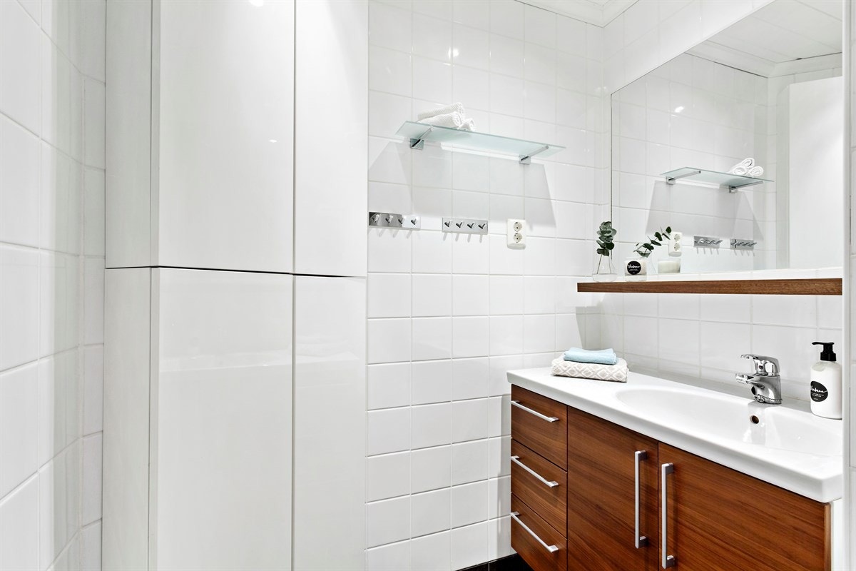 Her er det utstyrt med baderomsinnredning med nedfelt servant, høyskap, vegghengt toalett og dusjhjørne med innfellbare dører. Det er også opplegg for vaskemaskin samt uttak for tørketrommel som vil medfølge. Galleribilde