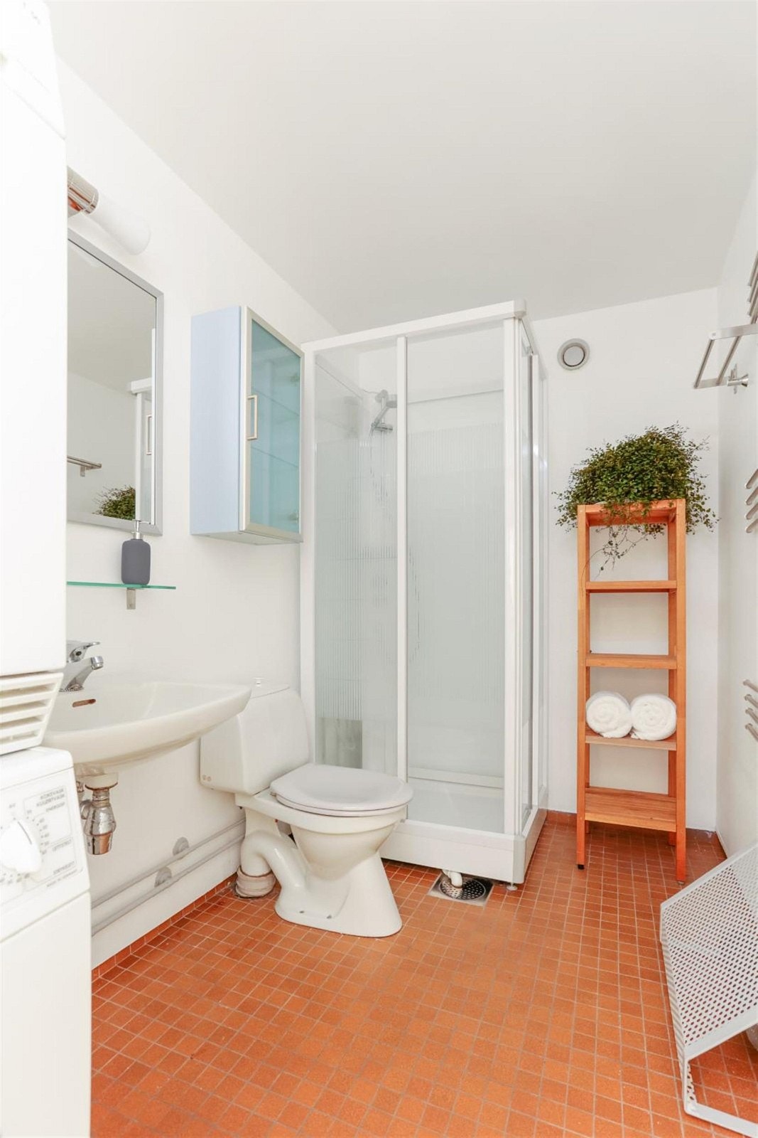 Bad innredet med toalett, dusjkabinett, servant og speil med overlys. Opplegg for vaskemaskin og tørketrommel Galleribilde