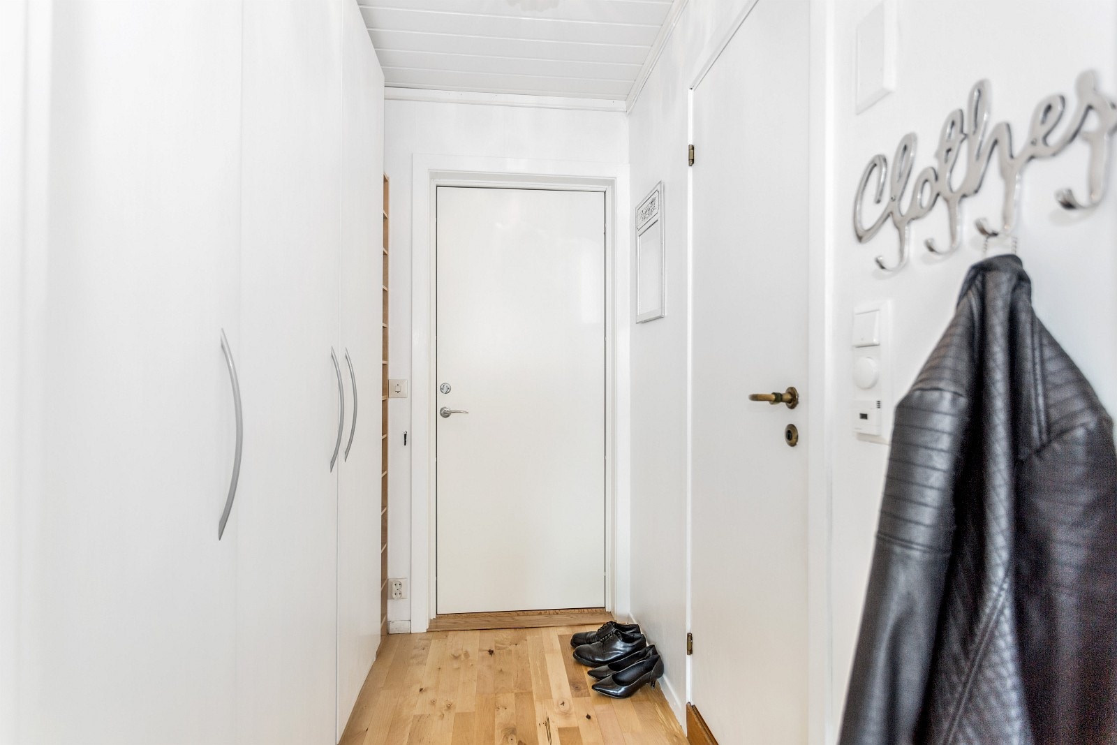 Gang med store gode garderobeskap med flere store hyller Galleribilde