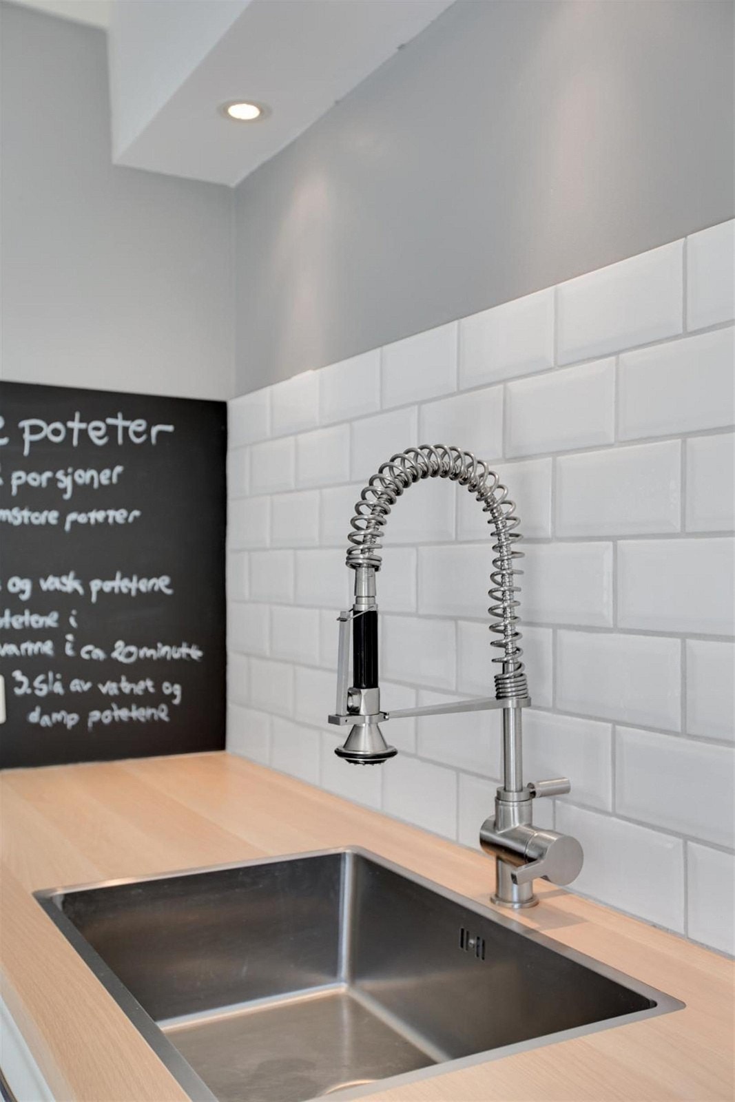 Keramiske fliser over laminat benkeplate med underlimt stål vaskekum. Galleribilde