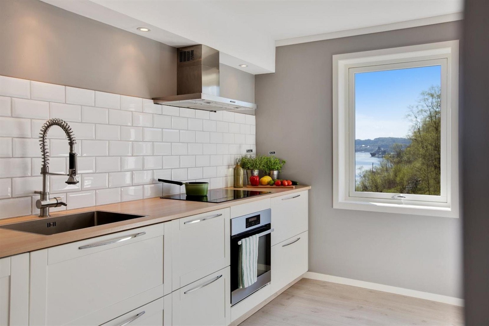 Integrerte hvitevarer som stekeovn, platetopp m/induksjon, oppvaskmaskin og kjøleskap/frys. Flott utsikt fra kjøkkenvinduet. Galleribilde