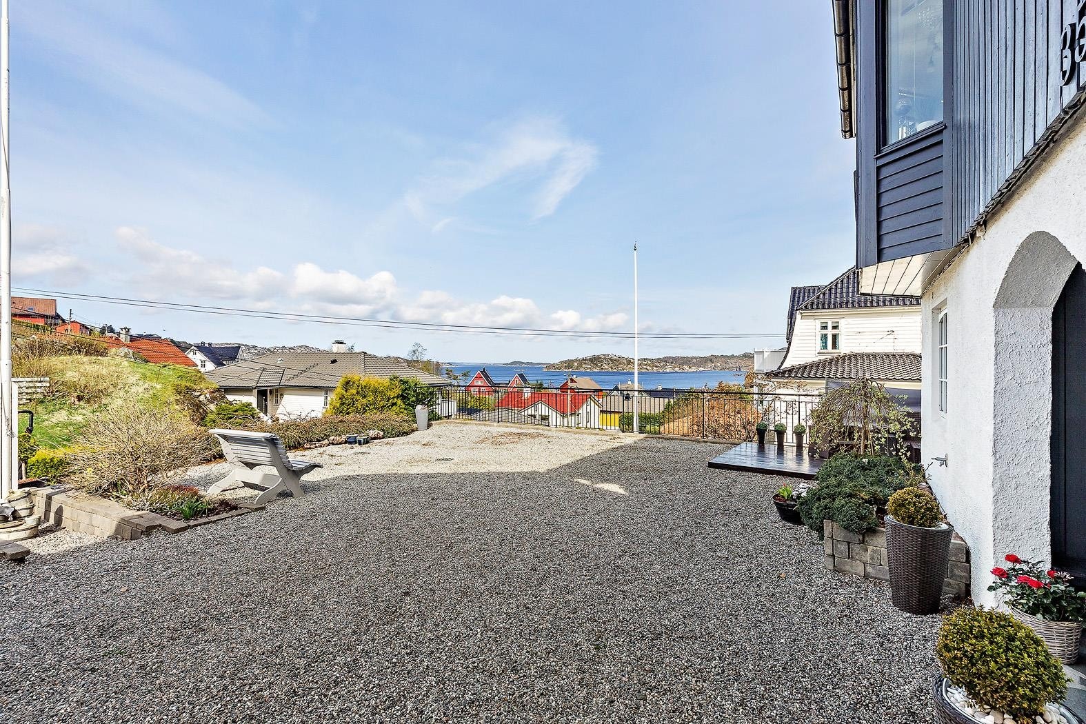 Fin og lettstelt gårdsplass. Overbygget inngangsparti til huset Galleribilde