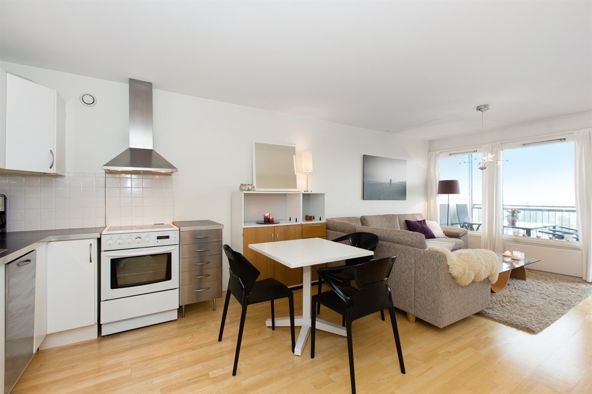 I stuen er det plass til både spisebord og sofagruppe - den flotte utsikten kan nytes fra hele rommet Galleribilde