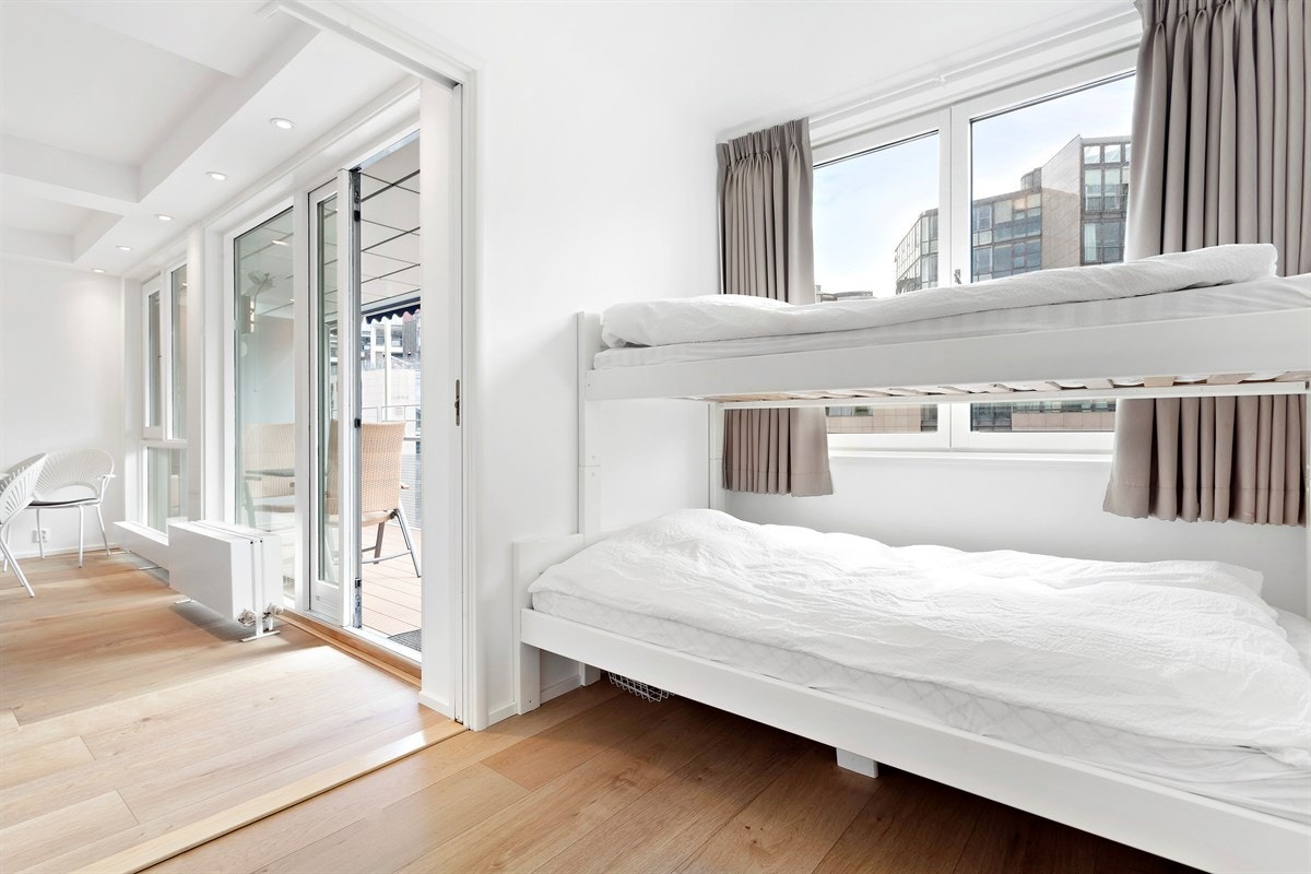 Soverom 2 med garderobeskap og utsikt over bryggetorget. Galleribilde