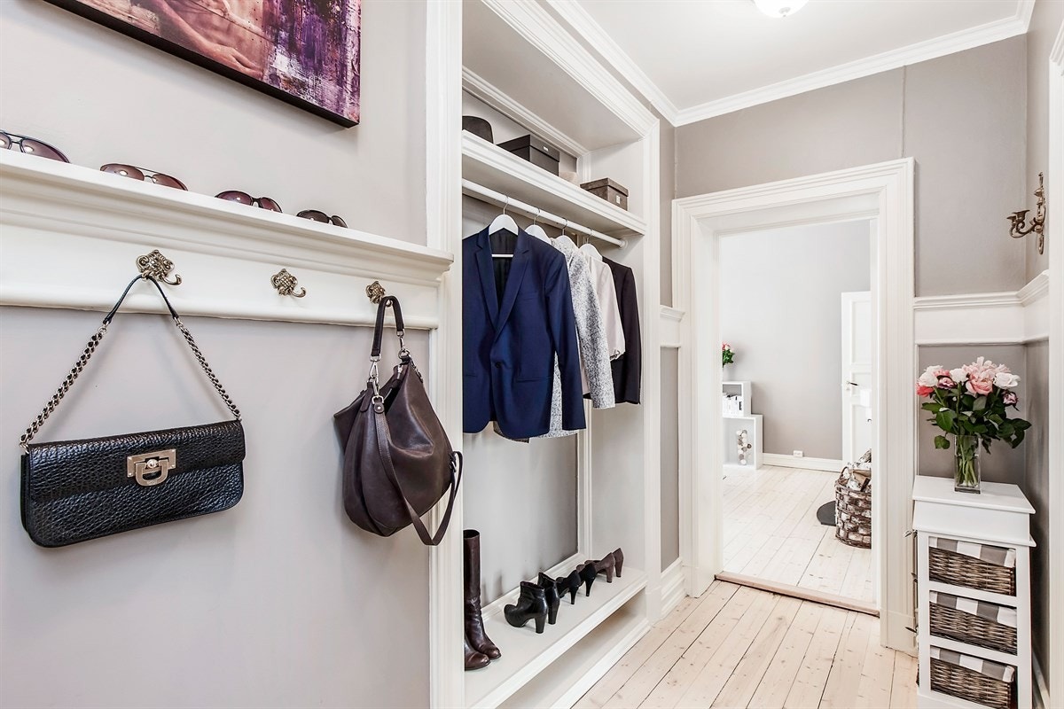 Plass til yttertøy og sko i skap og praktisk nisje med sko-, hattehylle og kleshengerstativ. Galleribilde