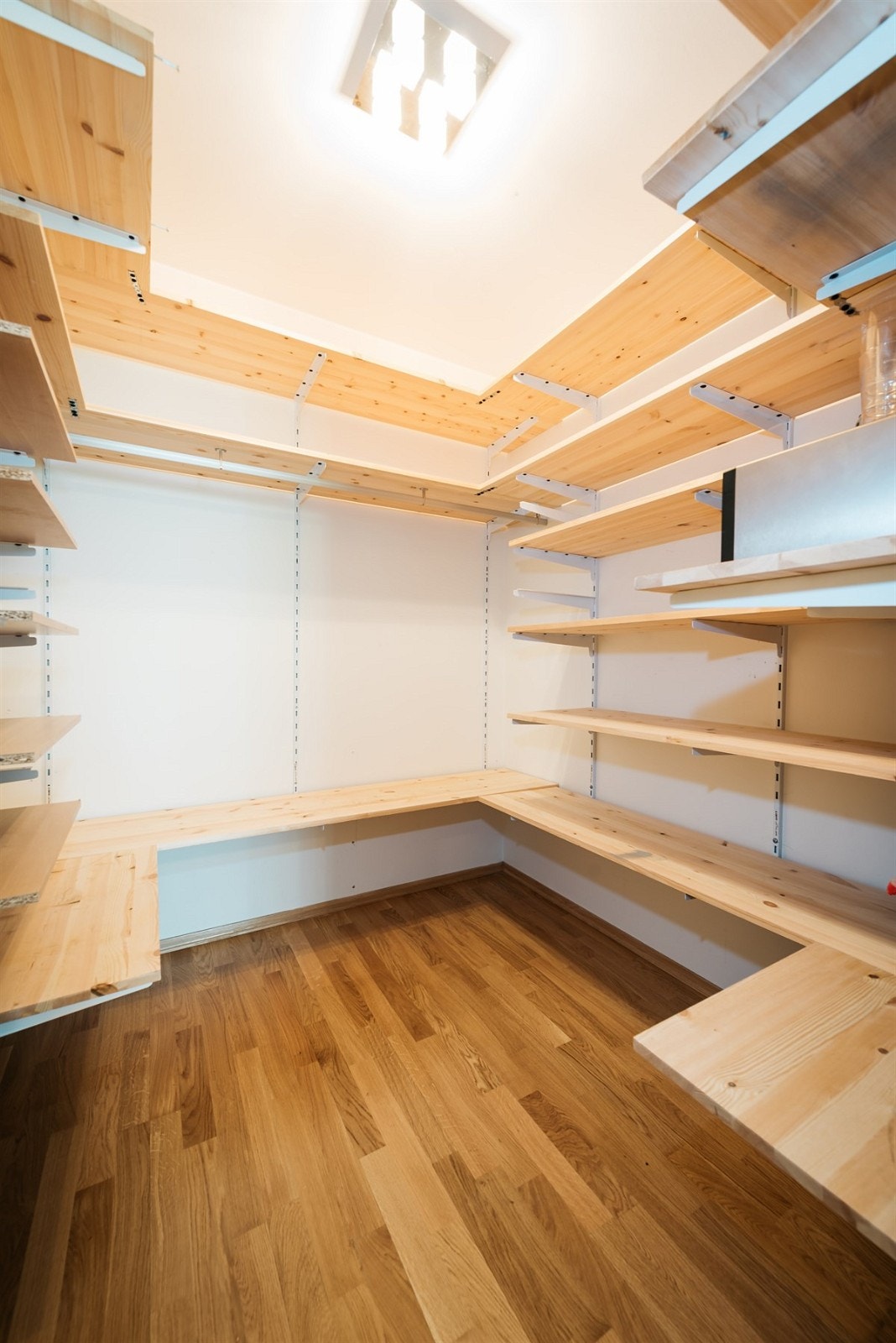 Bod/walk-in-closet med praktisk hyllesystem som optimaliserer oppbevaringsplassen Galleribilde