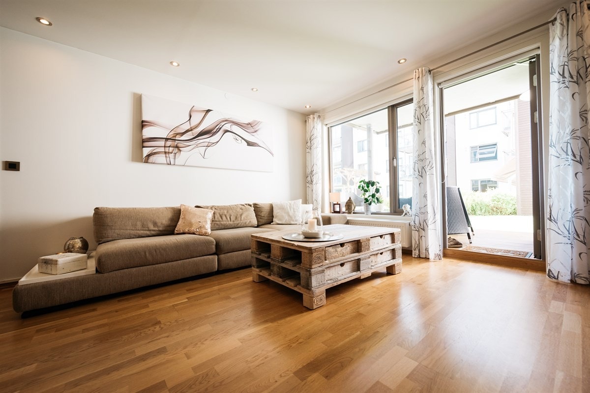 De store vindusflatene på endeveggen slipper mye naturlig dagslys inn i leiligheten Galleribilde