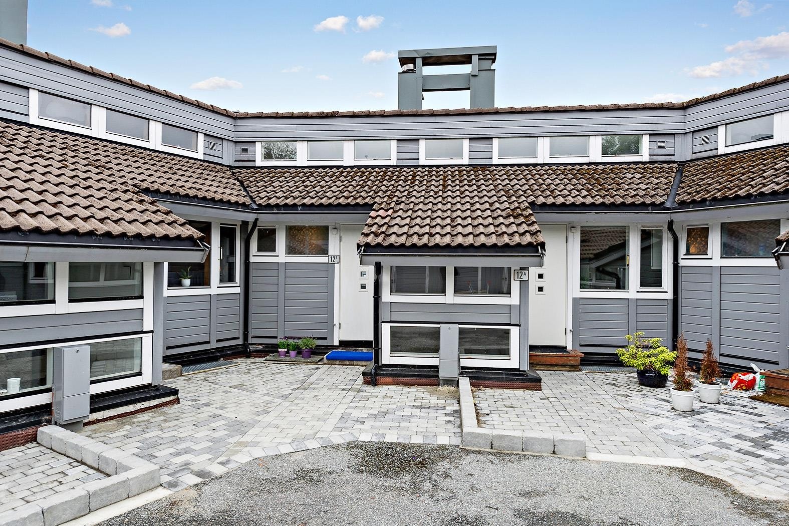 Selv om inngangspartiet til leiligheten er fra gateplan, ligger leiligheten i byggets toppetasje (2.etg.) sett fra fremsiden. Galleribilde