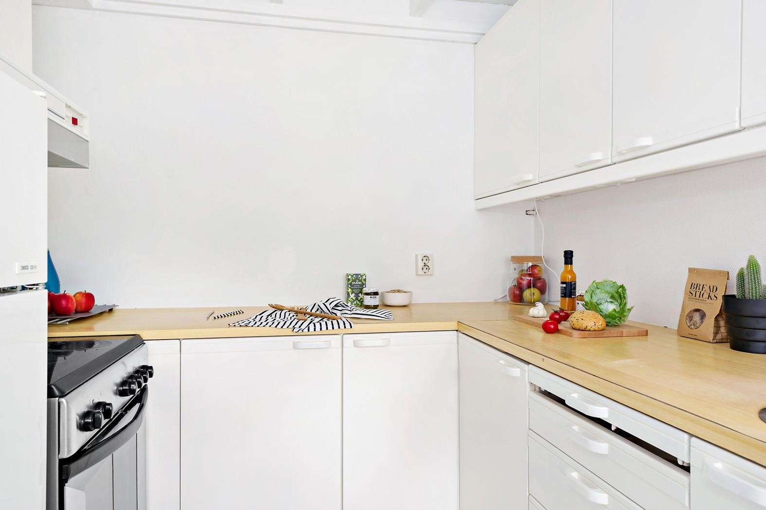 Kjøkkenet har en eldre hvitmalt innredning og laminat benkeplate Galleribilde