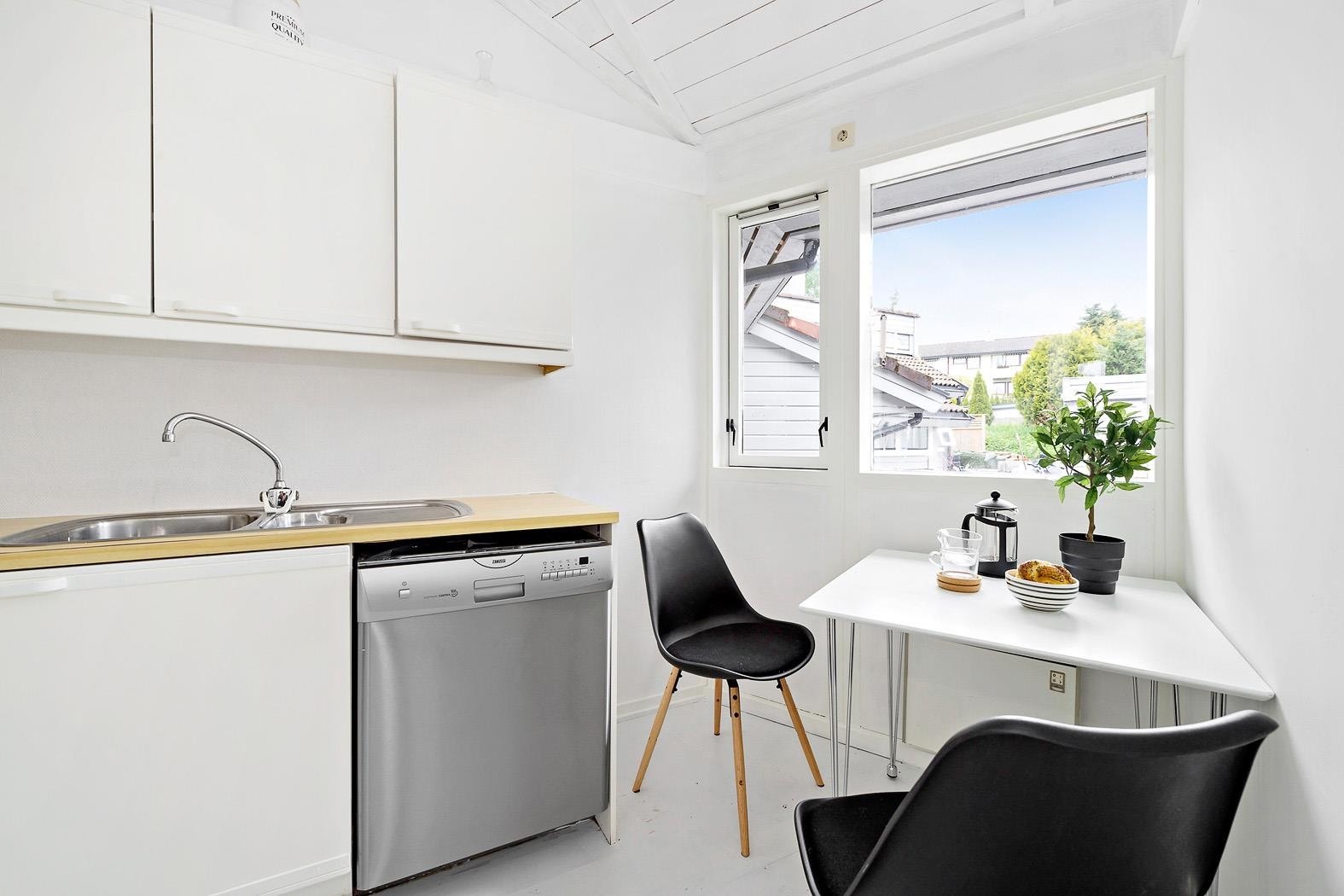 Inngang fra stuen til kjøkkenet med plass til en mindre frokostgruppe med vinduet Galleribilde