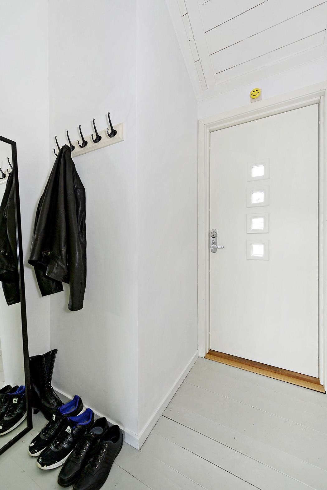 Man kommer inn i leilighetens lyse entré som har nymalte overflater og innhukk for plassering av yttertøy og sko. Galleribilde
